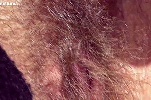 hairy mature woman sits in the car during outdoor drive