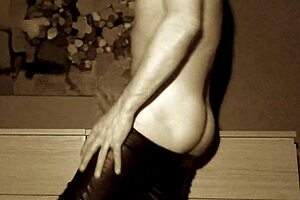 The performer casually strips while handling chains in a latex outfit during the routine.