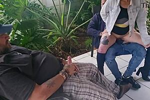 Friend rides wife outdoors as husband watches closely